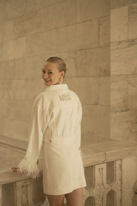 Personalized bride jacket that is white with feathers.
