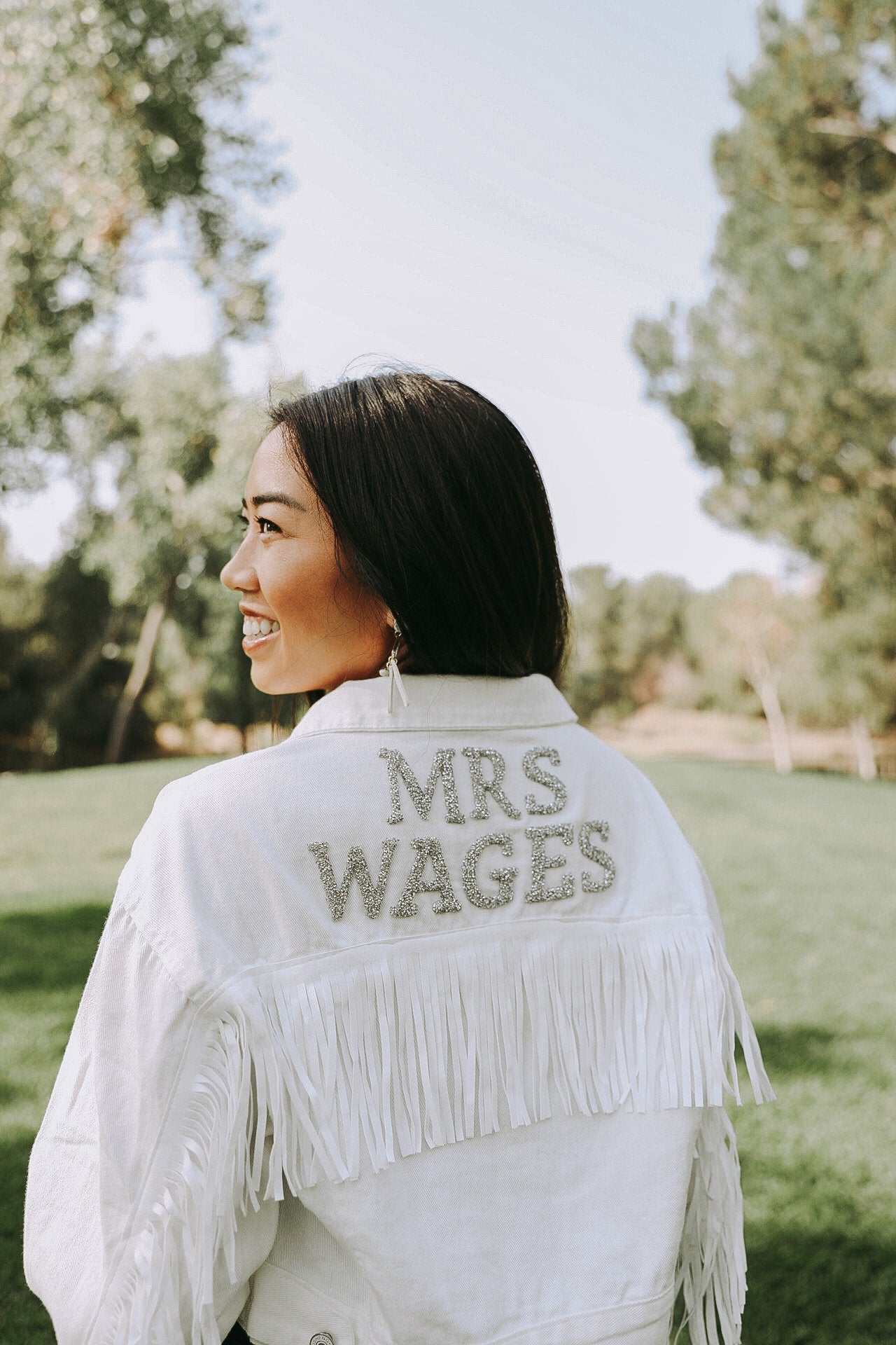 Personalized white fringe jacket with future last name in silver rhinestone patches.